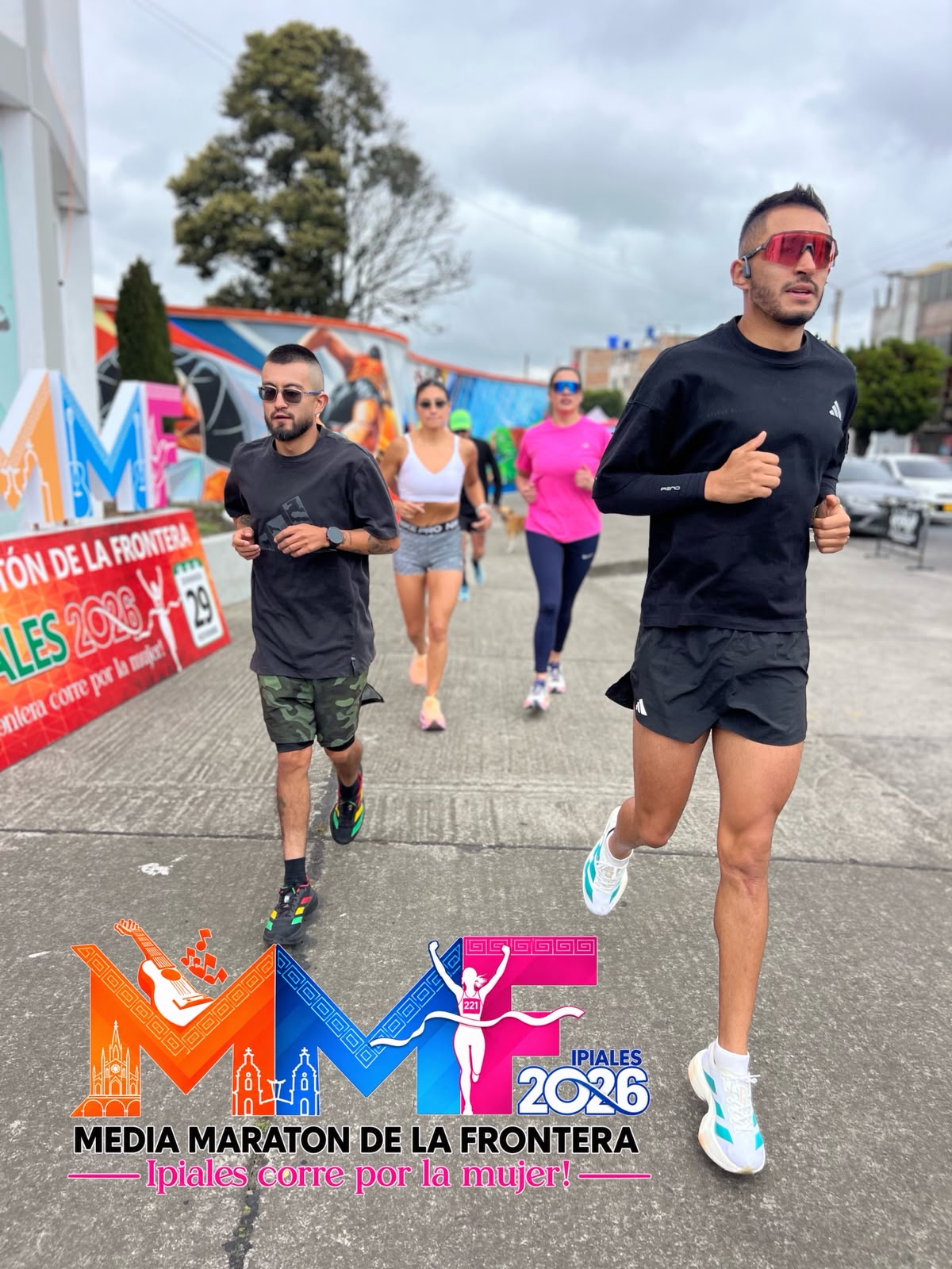 Grupo de corredores entrenando junto a la imagen de la Media Maratón de la Frontera